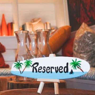 Mini surfboard with Reserved text at Shark Bar.