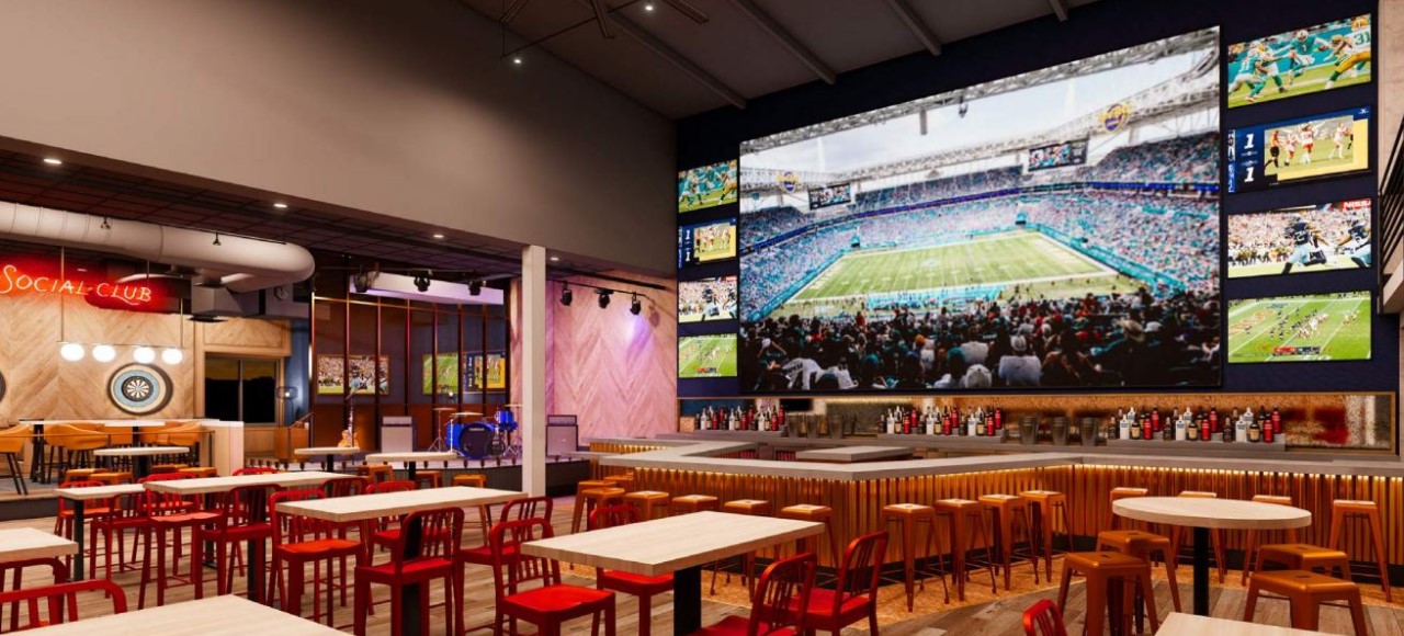 Sports & Social Orlando dining area, bar with media wall and large screen TVs, and music performance stage.